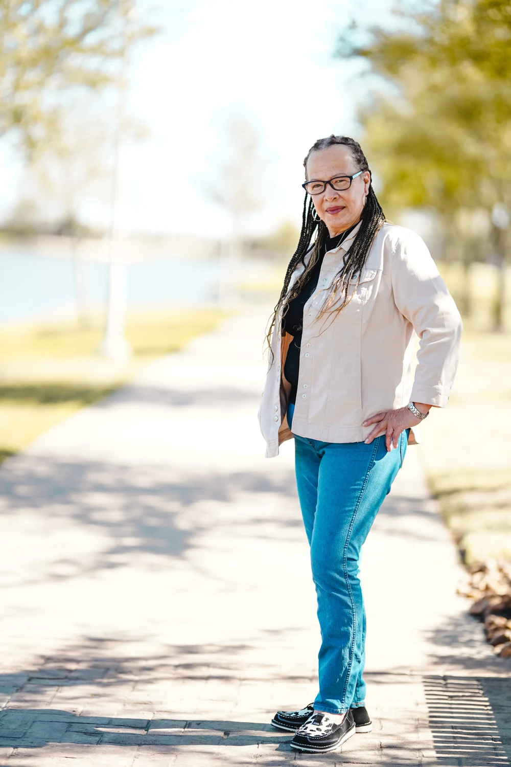 Joyce Dixson-Haskett standing outside on a tree-lined path